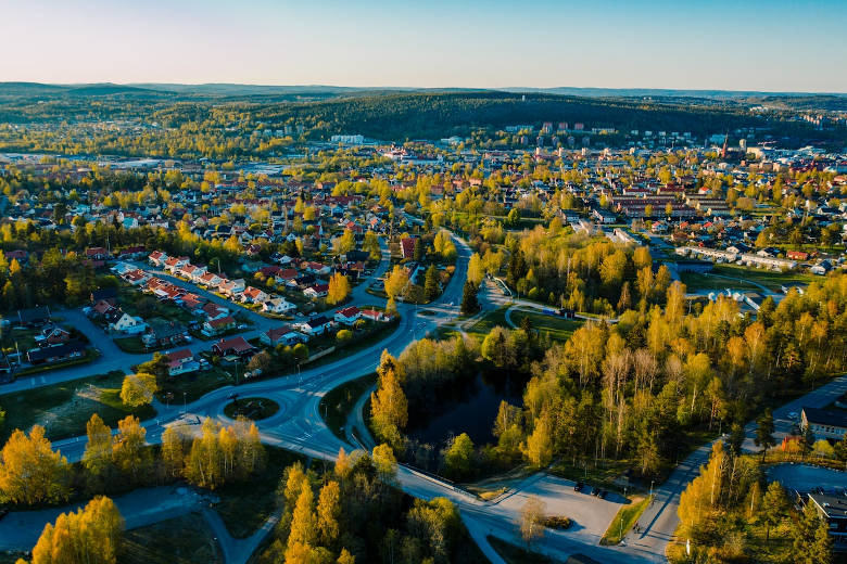 En stad och dess grönområden badar i solljus. Foto.